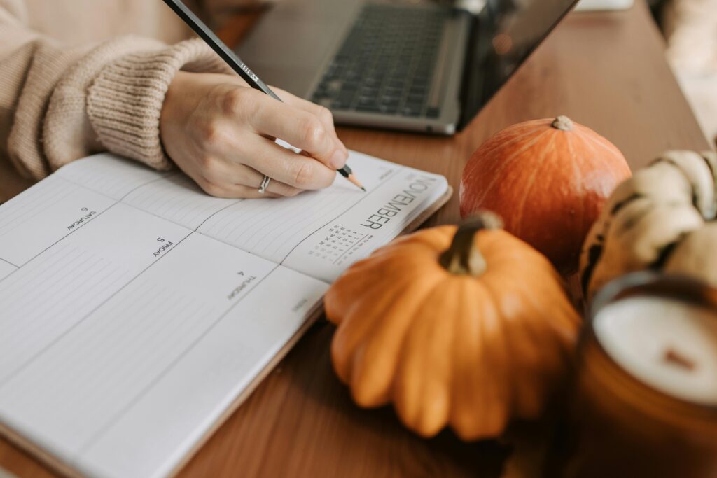 A cozy workspace with a planner, pumpkins, and a laptop, capturing the essence of autumn planning.