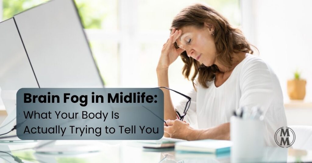 midlife woman overwhelmed with brain fog holding head at laptop feeling mentally fatigued