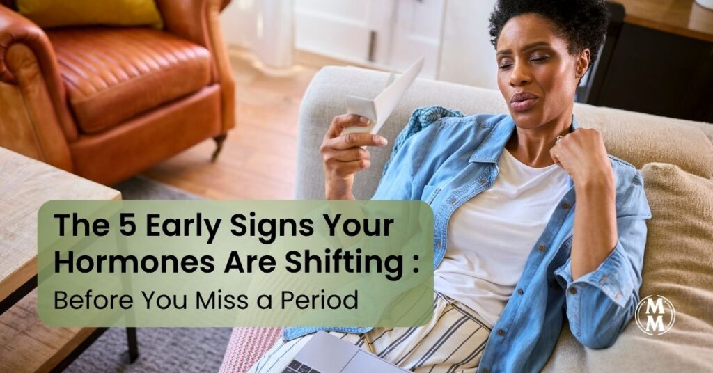 woman experiencing early signs hormones shifting midlife feeling warm using handheld fan at home