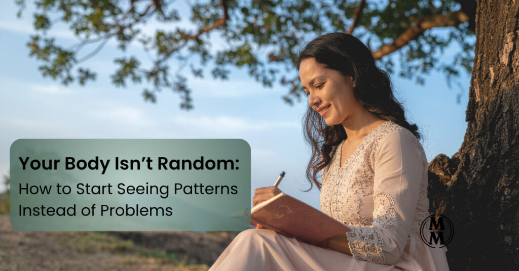 Woman reflecting on body signals and health patterns while journaling outdoors